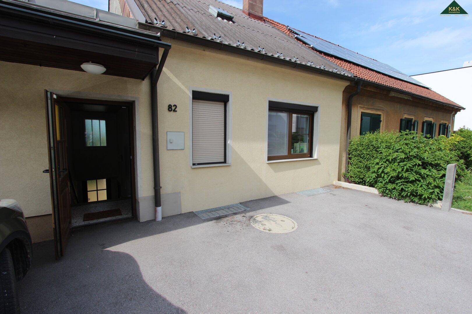 Vorderansicht des Hauses mit Einfahrt, Eingangstür und Solaranlage auf dem Dach.