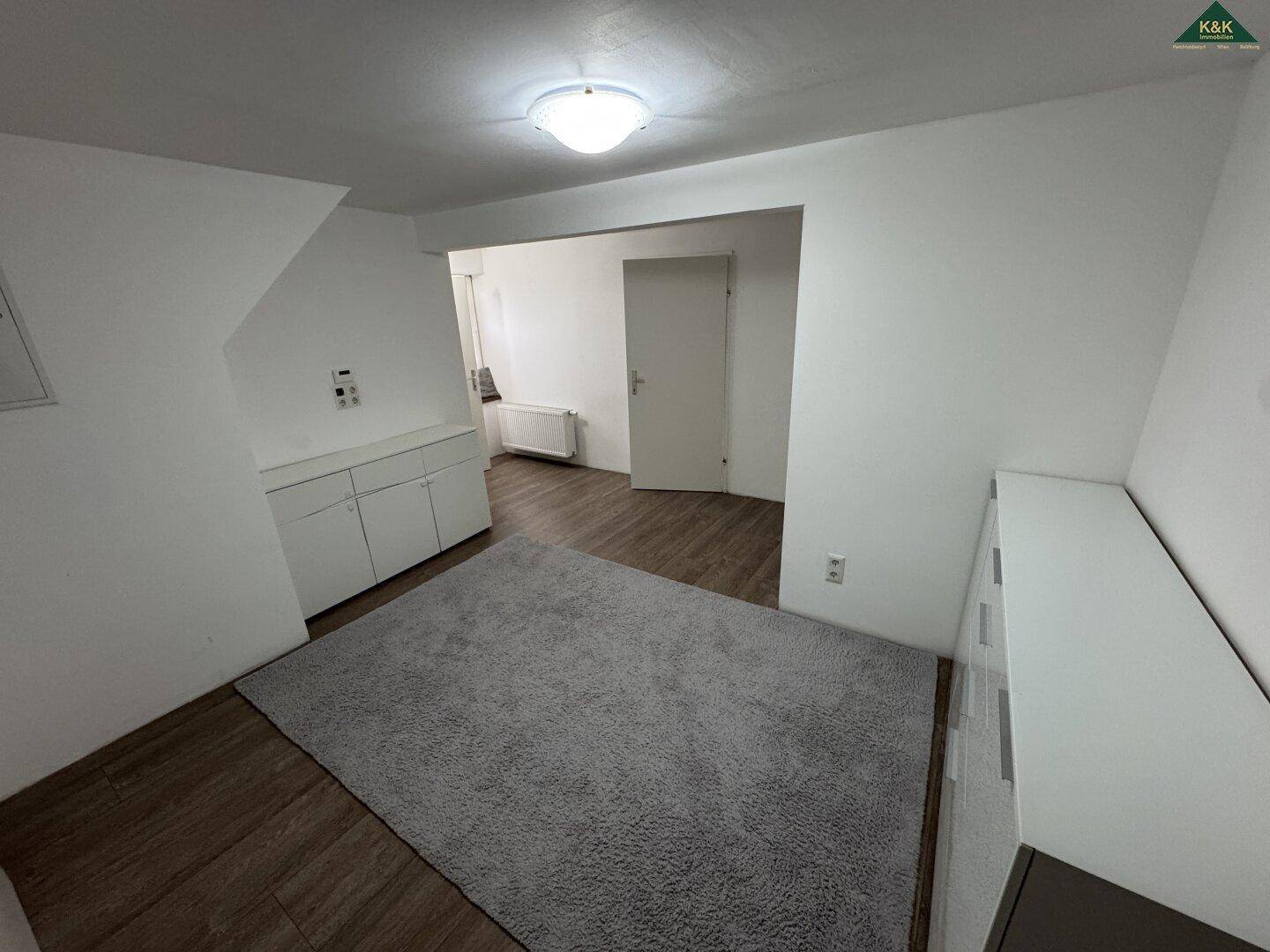 Geräumiges Zimmer im Dachgeschoss mit Teppich und vielseitiger Nutzungsmöglichkeit.
