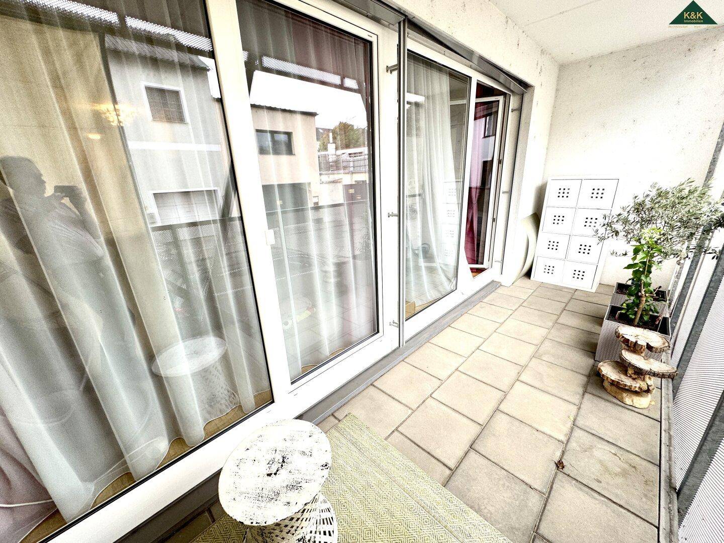 Heller Balkon mit großen Schiebetüren, die viel Tageslicht in den Innenraum lassen.