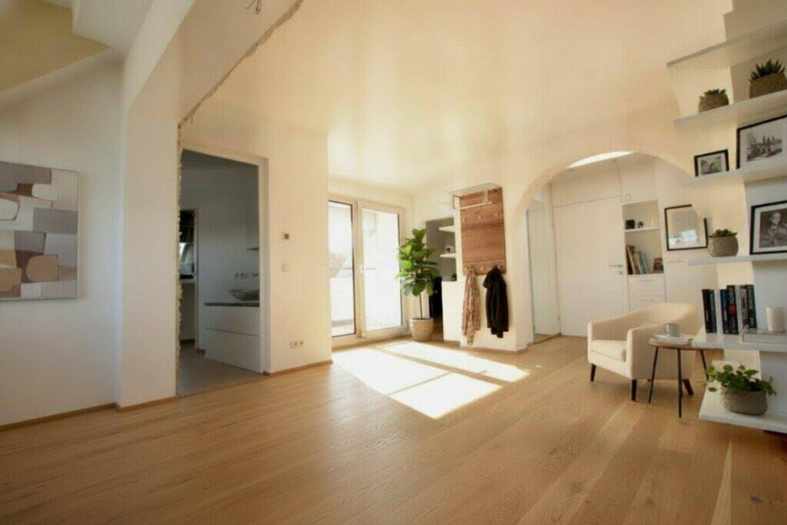 Heller Eingangsbereich mit Holzboden, Garderobe und Zugang zu weiteren Räumen.