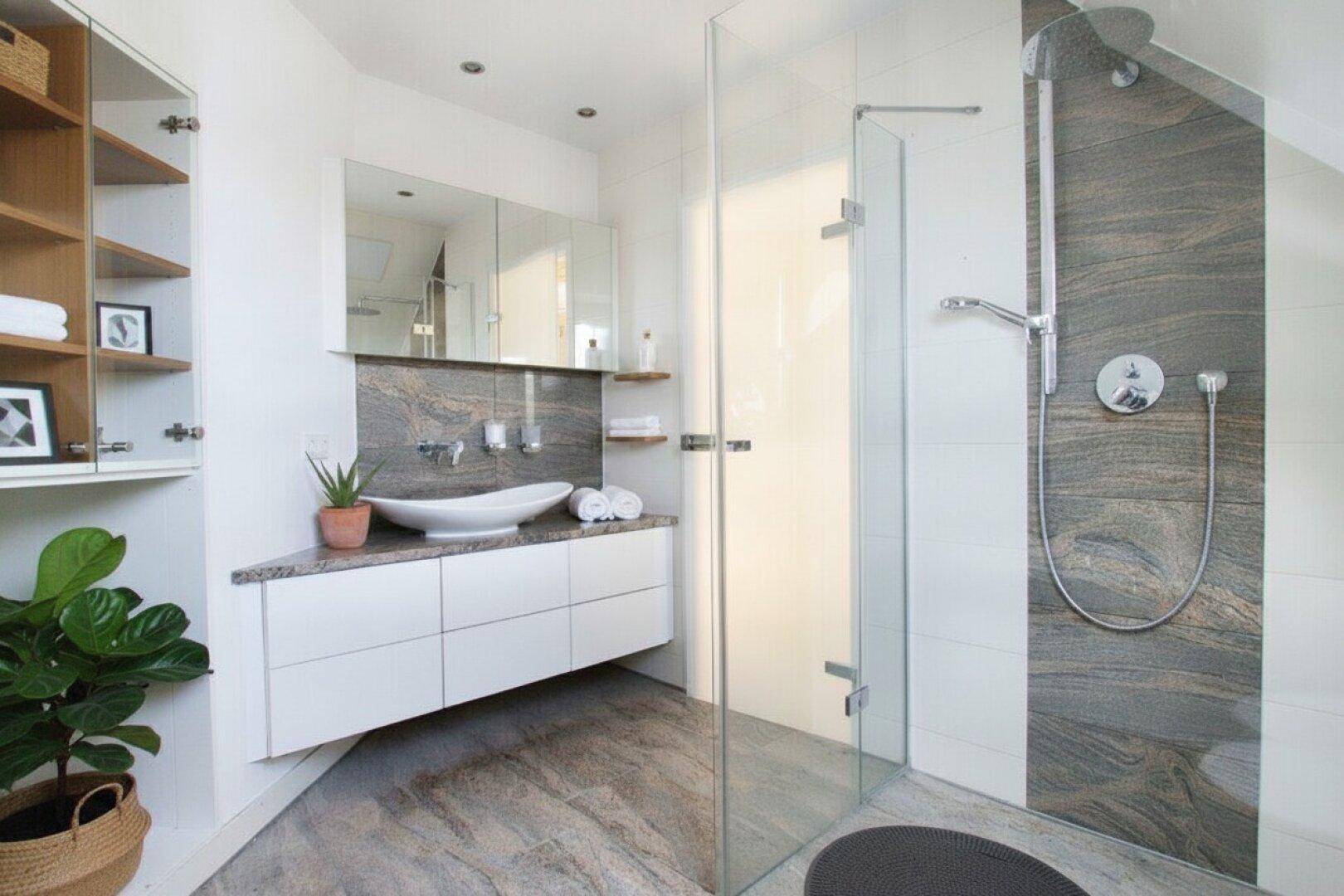 Elegantes Badezimmer mit großem Waschbecken, Spiegelschrank und begehbarer Dusche.