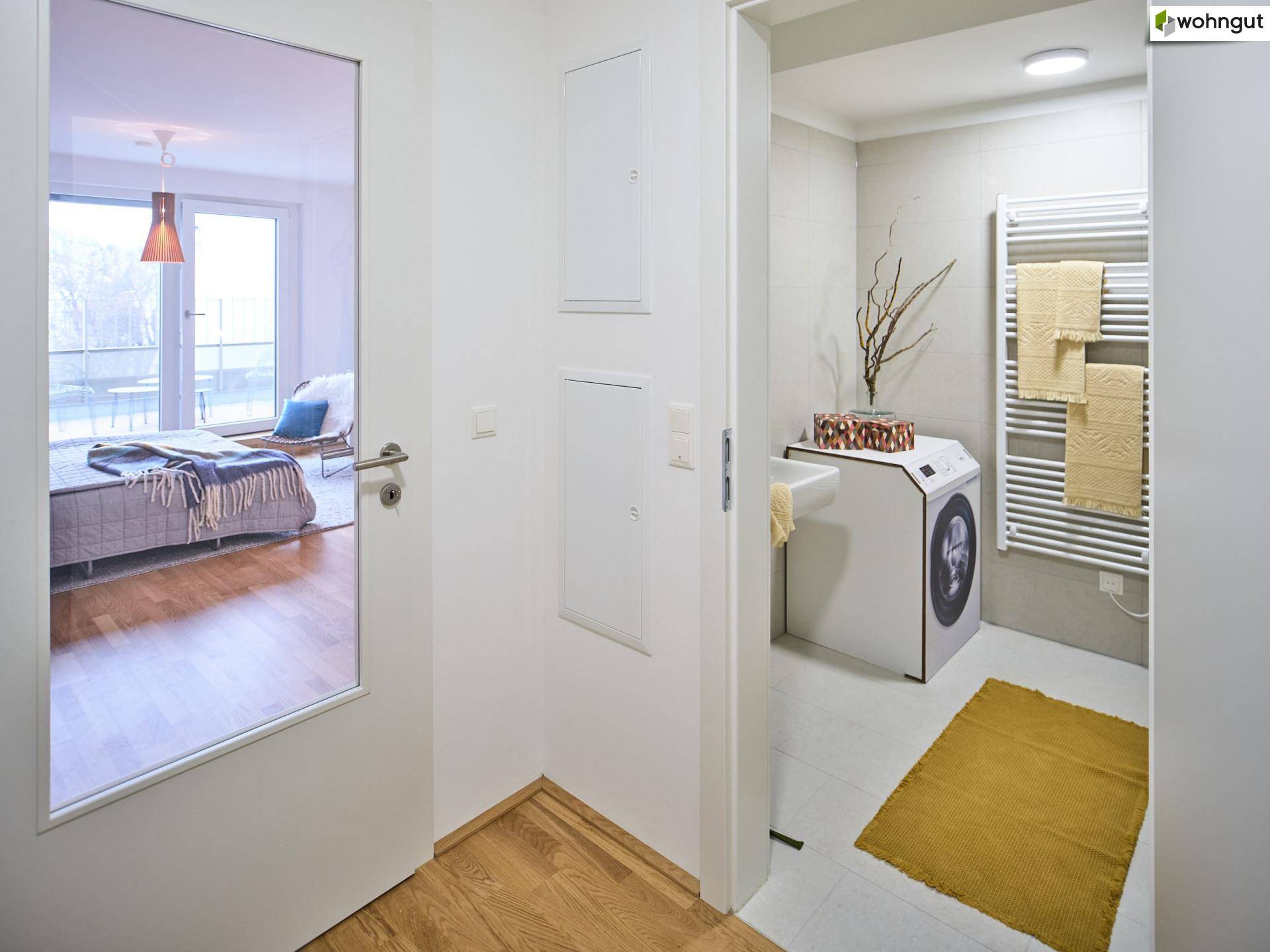 Heller Flur mit Zugang zu Badezimmer und Schlafzimmer, ausgestattet mit Holzboden.