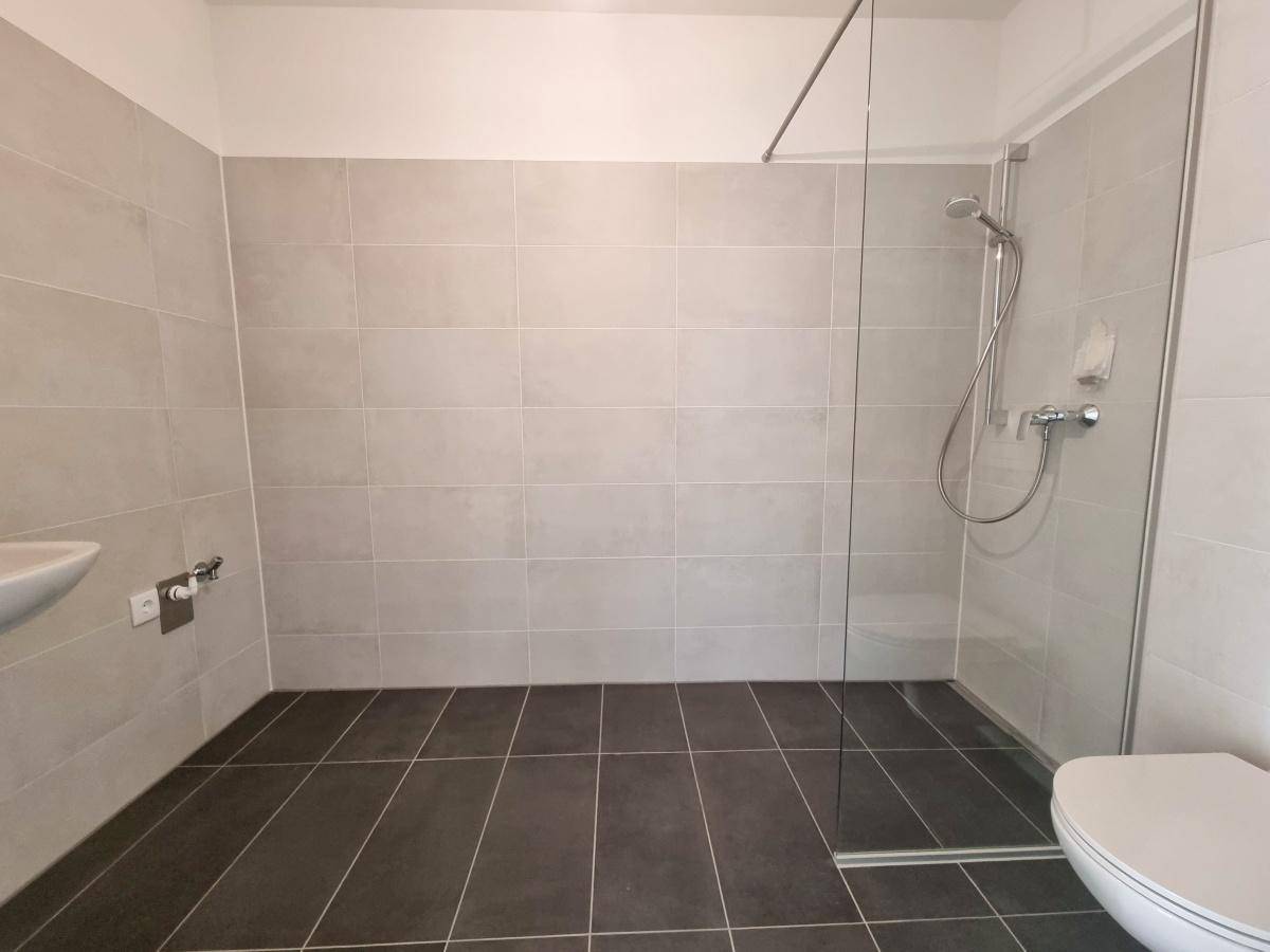 Geräumiges Badezimmer mit Dusche, WC und modernem Design.