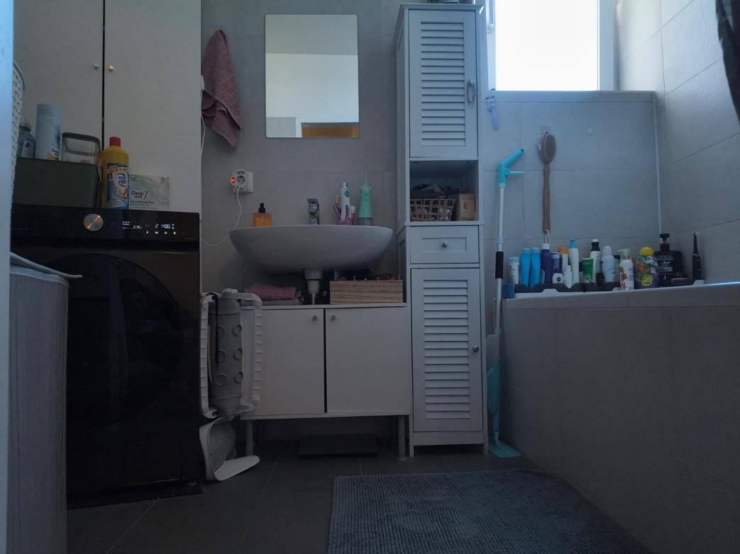 Badezimmer mit Waschbecken, Badewanne und einer Waschmaschine.