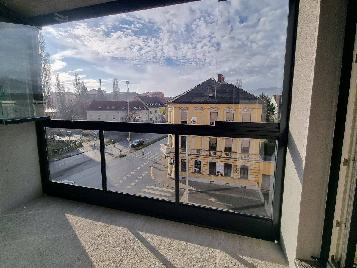 Verglaste Loggia mit Blick auf die Straße und die umliegenden Gebäude.