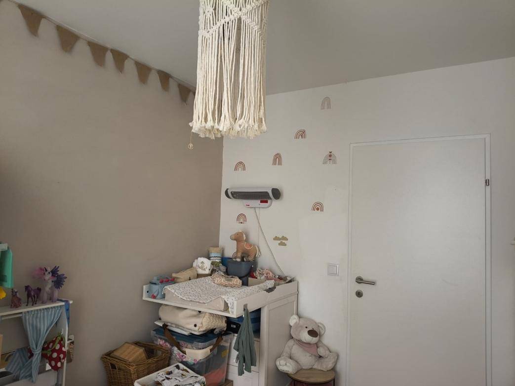 Kinderzimmer mit Wickeltisch, Wanddekoration und einer Tür.