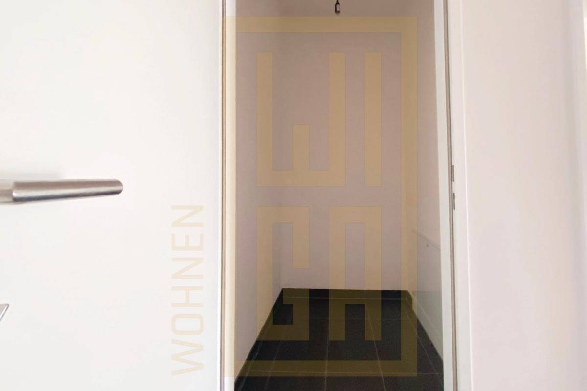 Praktischer Abstellraum mit dunklen Fliesen, ideal für zusätzlichen Stauraum.