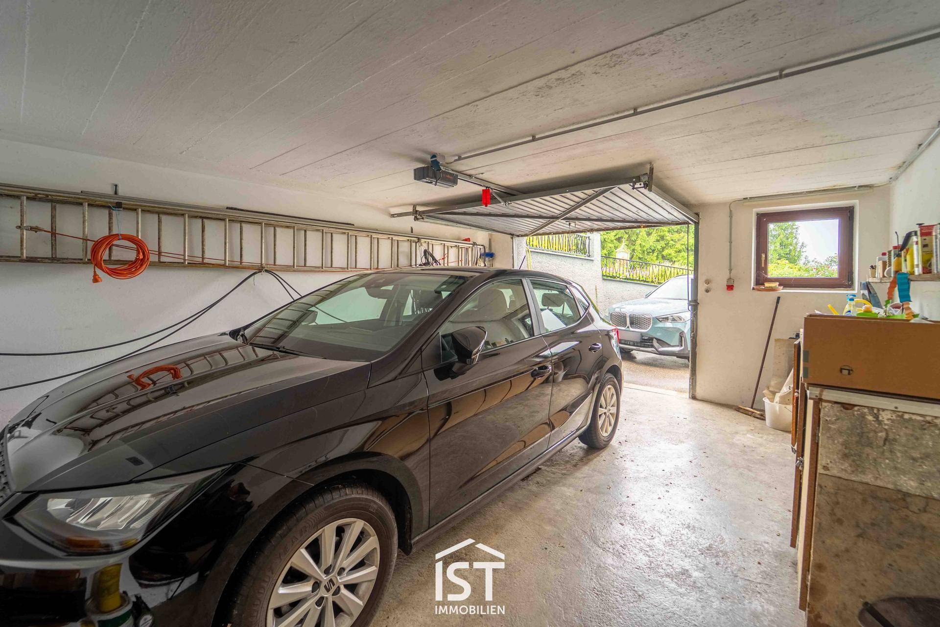 Geräumige Garage mit einem geparkten Auto und Stauraum.
