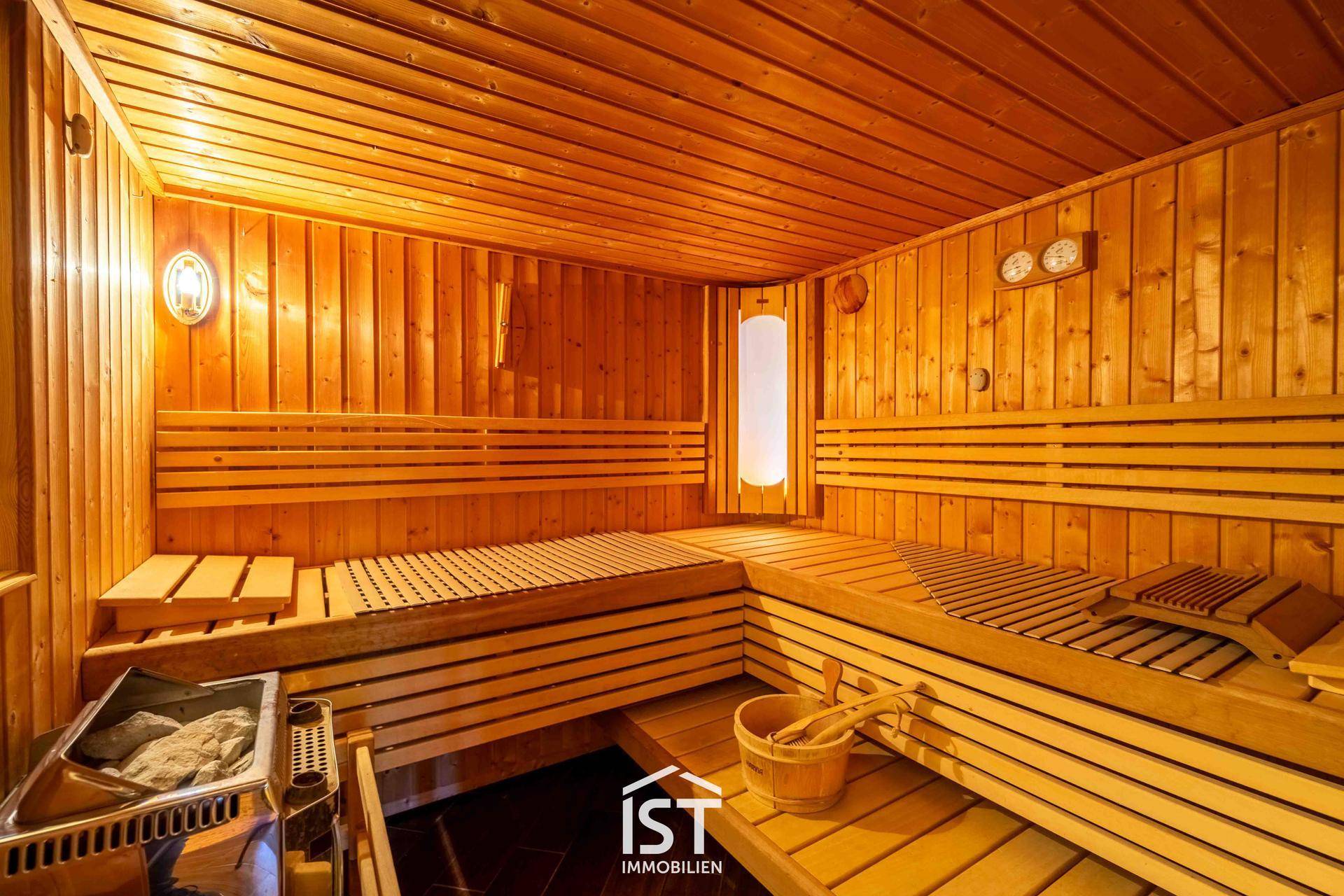 Geräumige Holzsauna mit mehreren Bänken und traditionellem Saunaofen für Entspannung.
