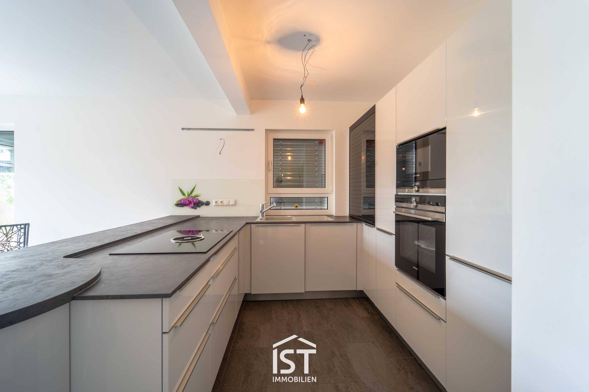 Stilvolle Einbauküche mit integrierten Geräten, Backofen und Kühlschrank.