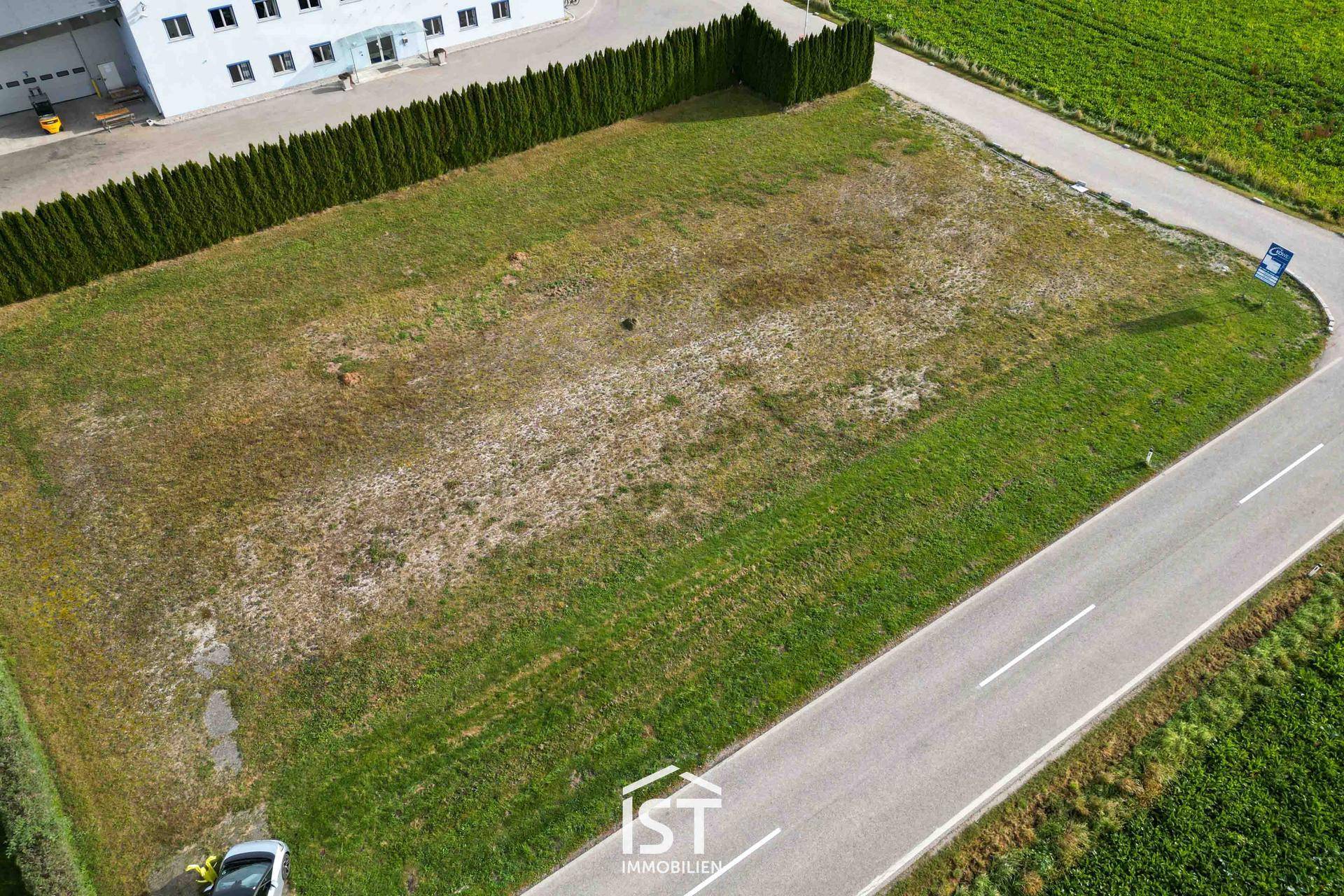 Übersicht des weitläufigen Grundstücks aus der Vogelperspektive mit angrenzender Straße und Feldern.