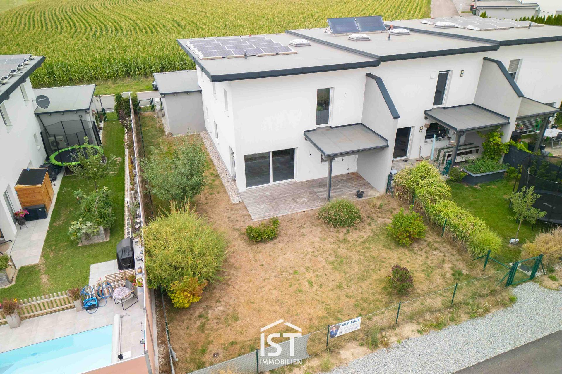 Hinterhof eines modernen Reihenhauses mit Terrasse, Garten und privatem Pool.