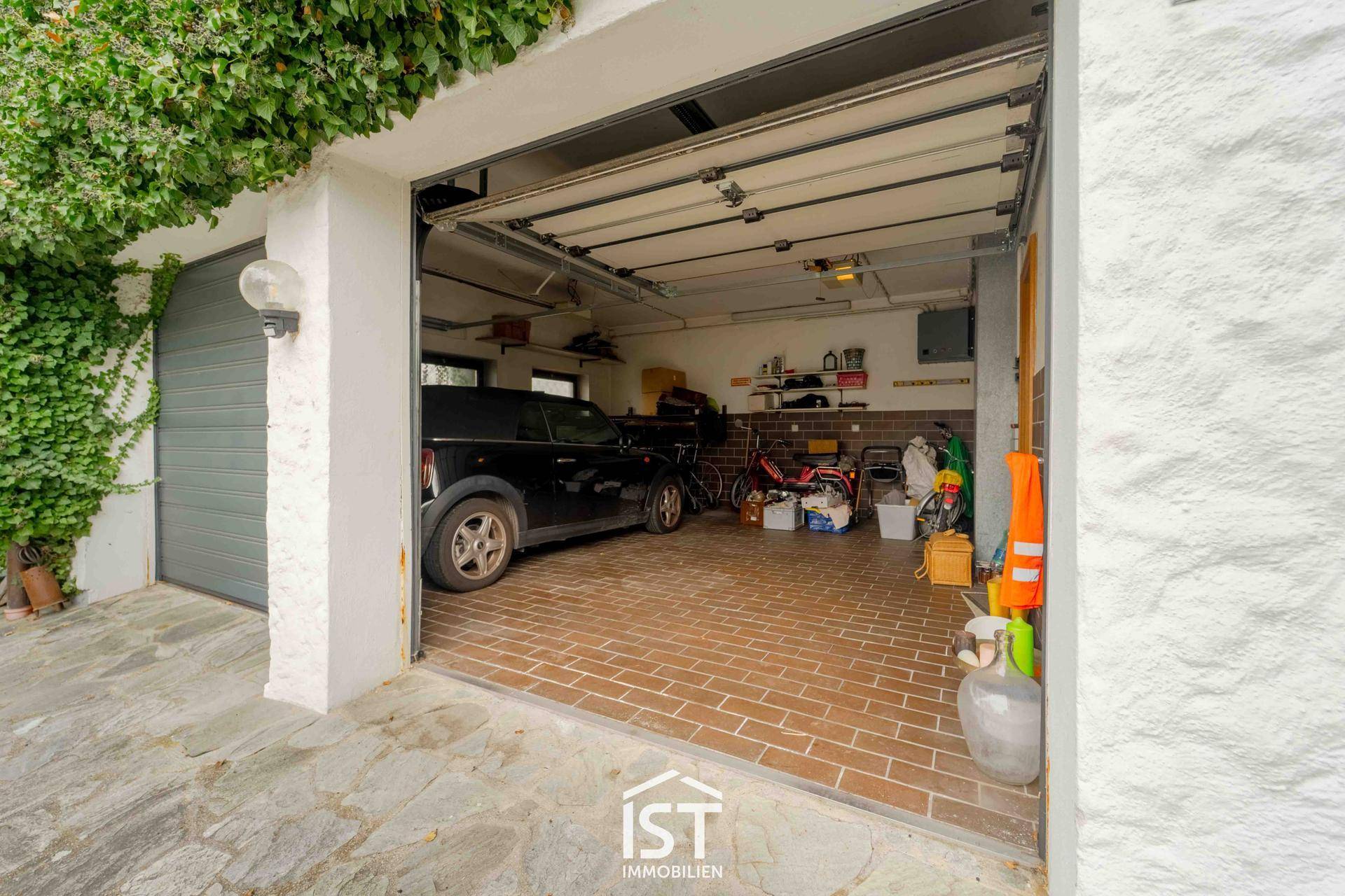 Geräumige Garage mit Platz für zwei Fahrzeuge und Stauraum für Fahrräder und Geräte.