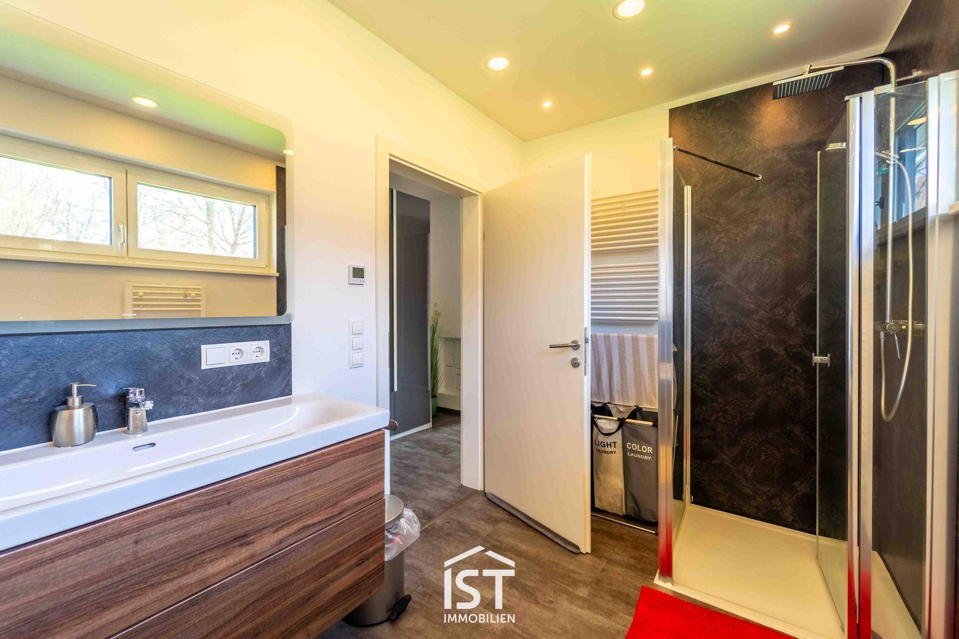 Modernes Badezimmer mit ebenerdiger Dusche, Fenster und stilvollem Waschbecken.