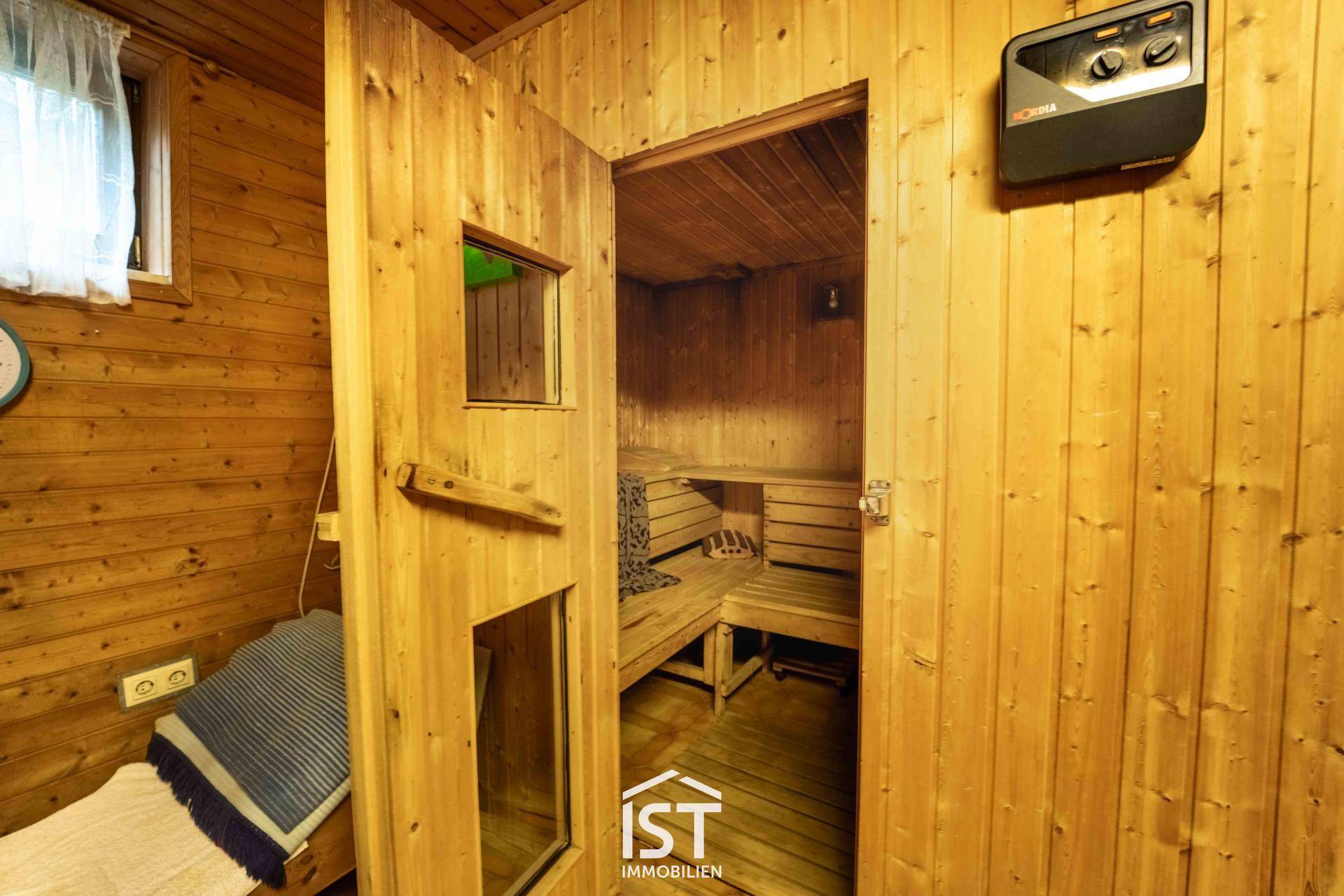 Gemütliche Holzsauna mit Heizofen und Sitzbänken für entspannende Momente.