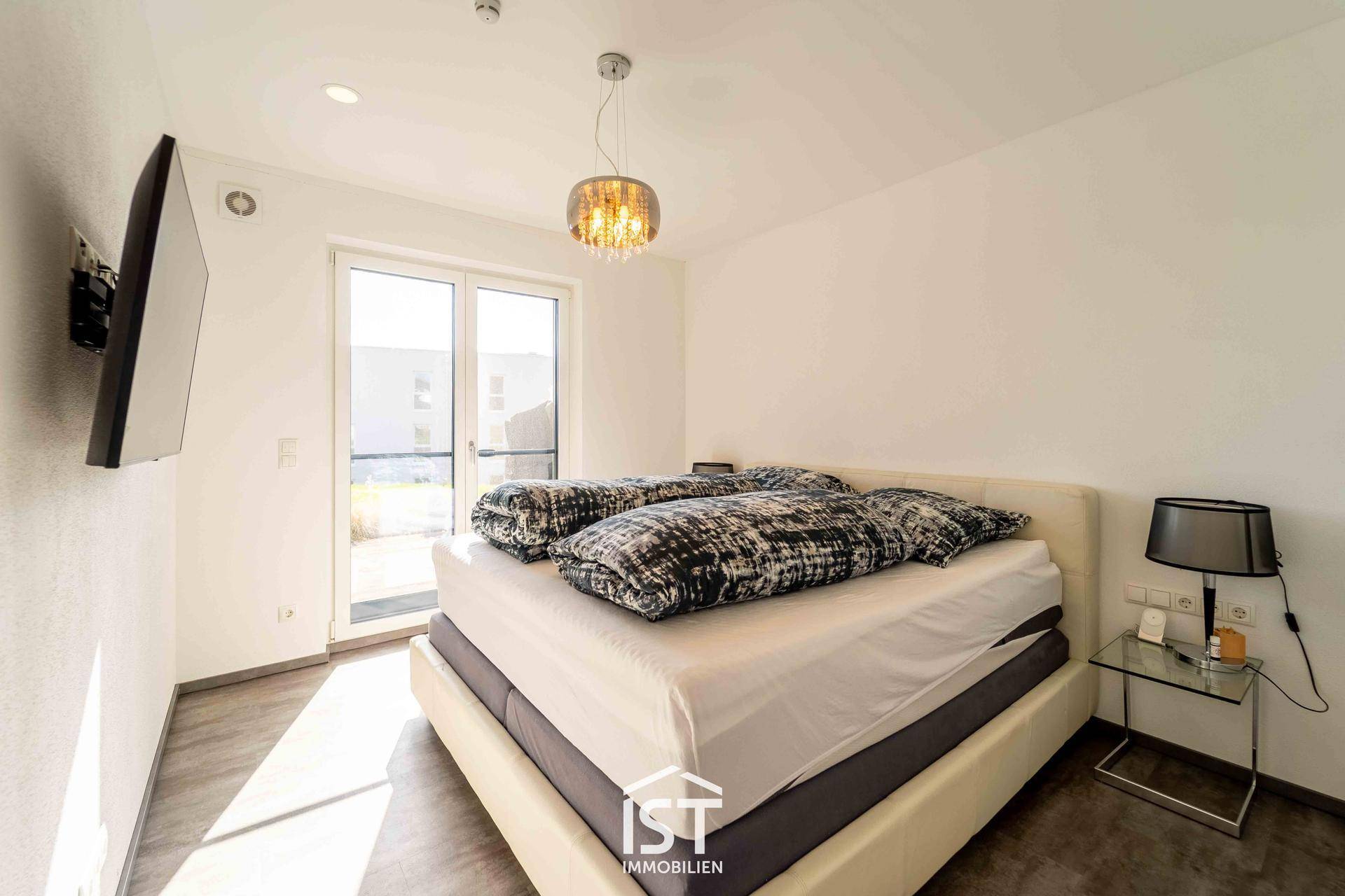 Helles Schlafzimmer mit Doppelbett und direktem Zugang zum Gartenbereich.