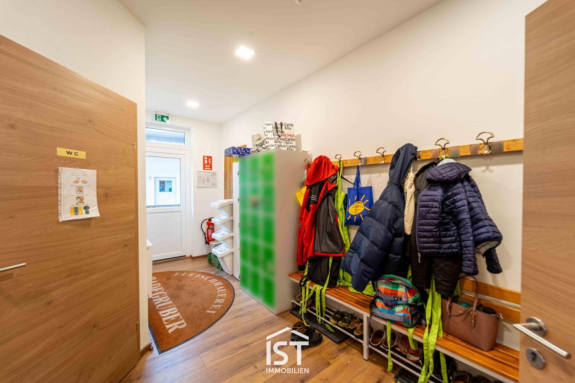 Eingangsbereich mit Garderobe, Sitzbank und Schuhregal, ideal für Kinder oder Mitarbeiter.