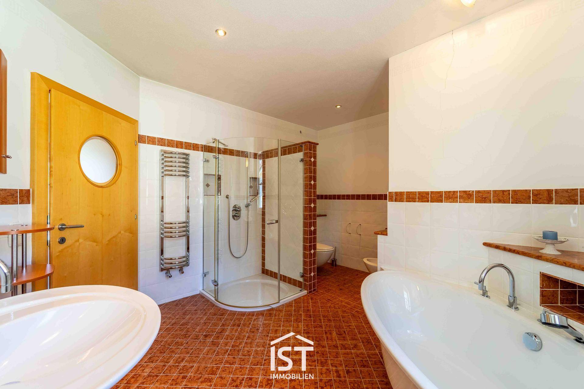 Großes Badezimmer mit Badewanne, Dusche, Bidet und beheiztem Handtuchhalter.