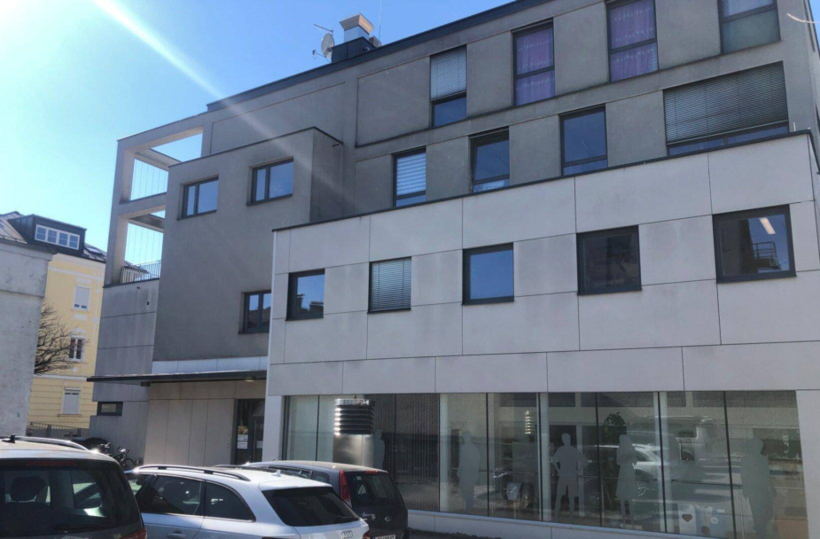 Modernes Geschäftsgebäude mit mehreren Etagen, großen Fenstern und einer klaren, funktionalen Architektur.