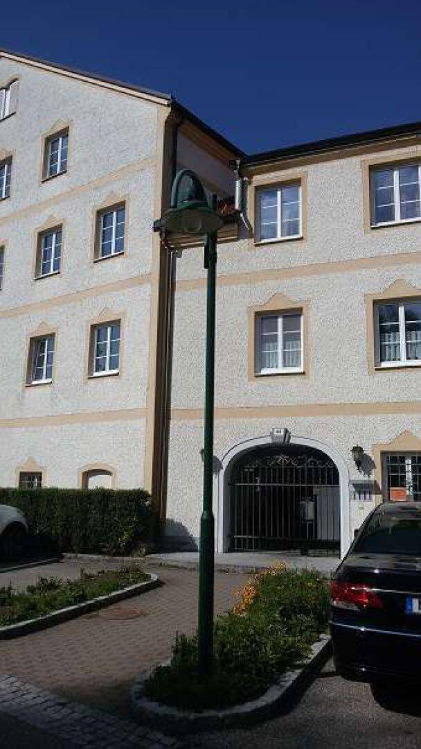 Fassade eines Gebäudes mit traditioneller Architektur, Bogenportal und Außenbeleuchtung.