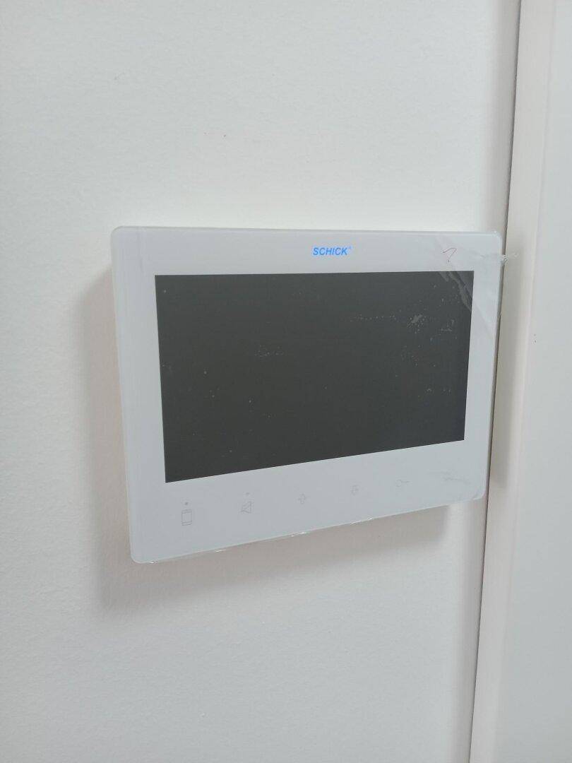 Modernes Gegensprechanlagendisplay an einer weißen Wand, bereit für die erste Nutzung.