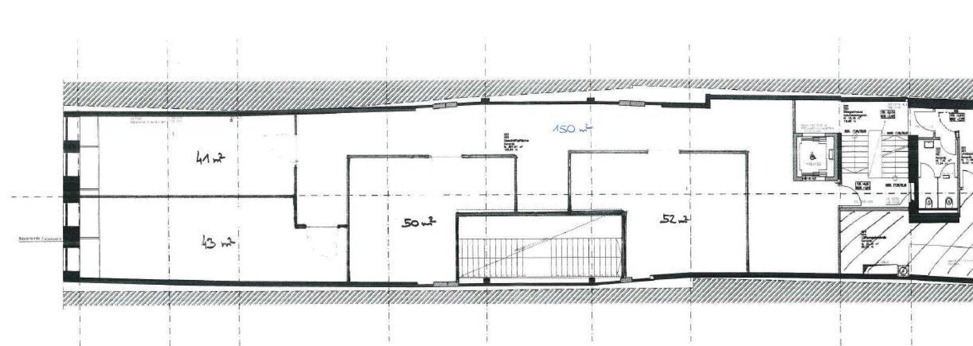Detaillierter Grundriss eines langen Gebäudegeschosses mit offenem Layout, Treppenhaus und Aufzug.