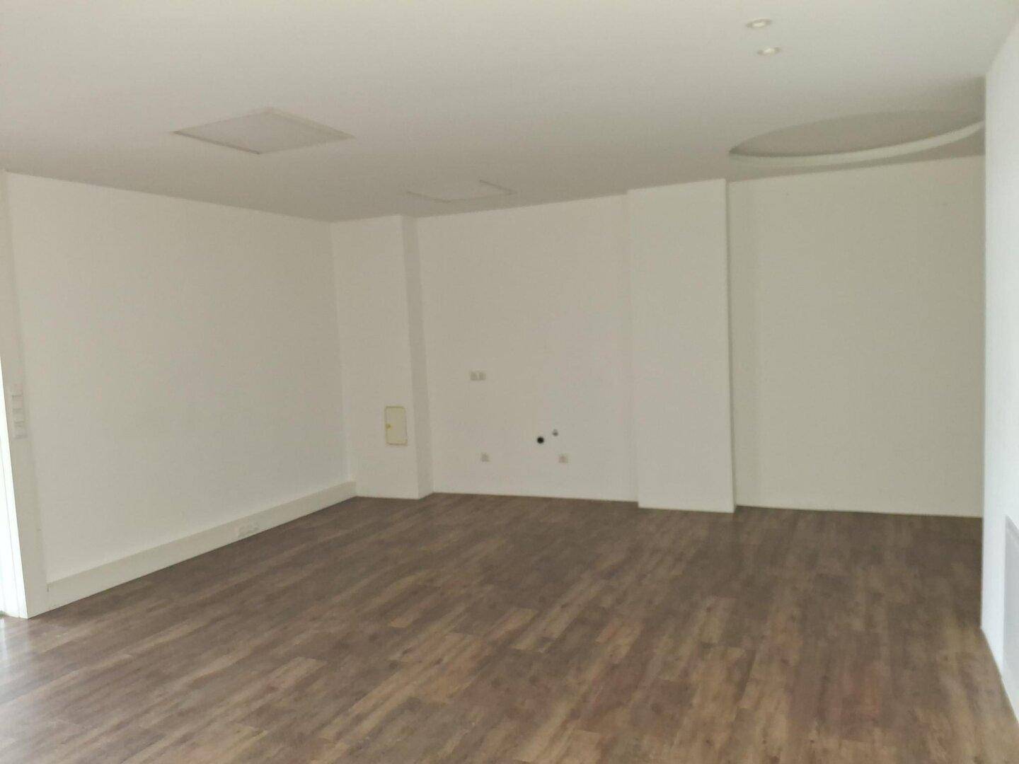 Großer, heller Gewerberaum mit Laminatboden und sauber gestrichenen Wänden, in sehr gutem Zustand.