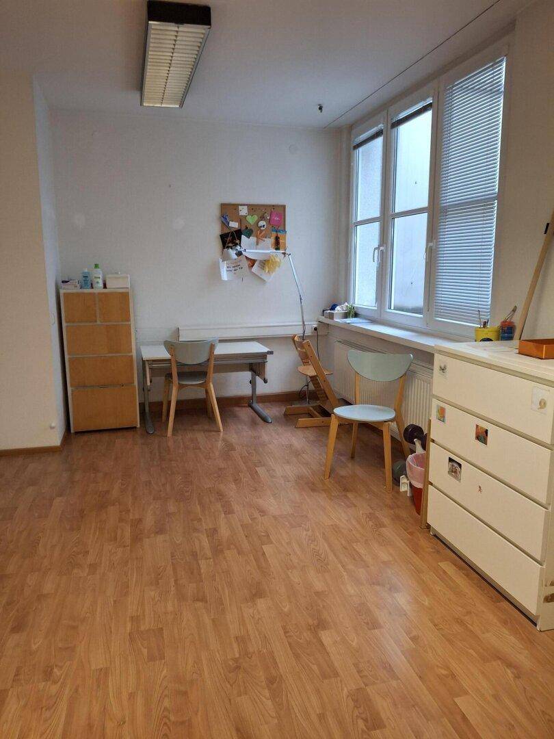 Helles Büro mit Holzboden, großem Fenster und Schreibtischbereich für administrative Aufgaben und Beratung.