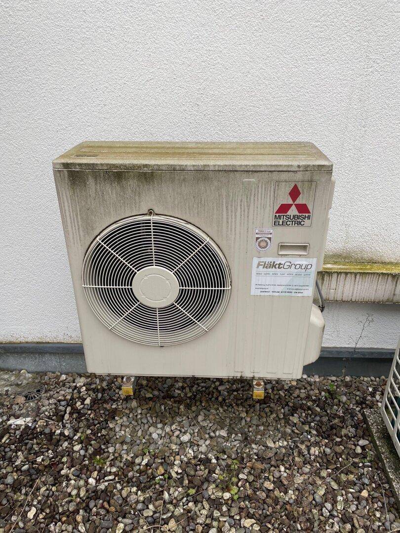 Eine Mitsubishi Electric Klimaanlage im Außenbereich des Gebäudes auf Kiesboden.