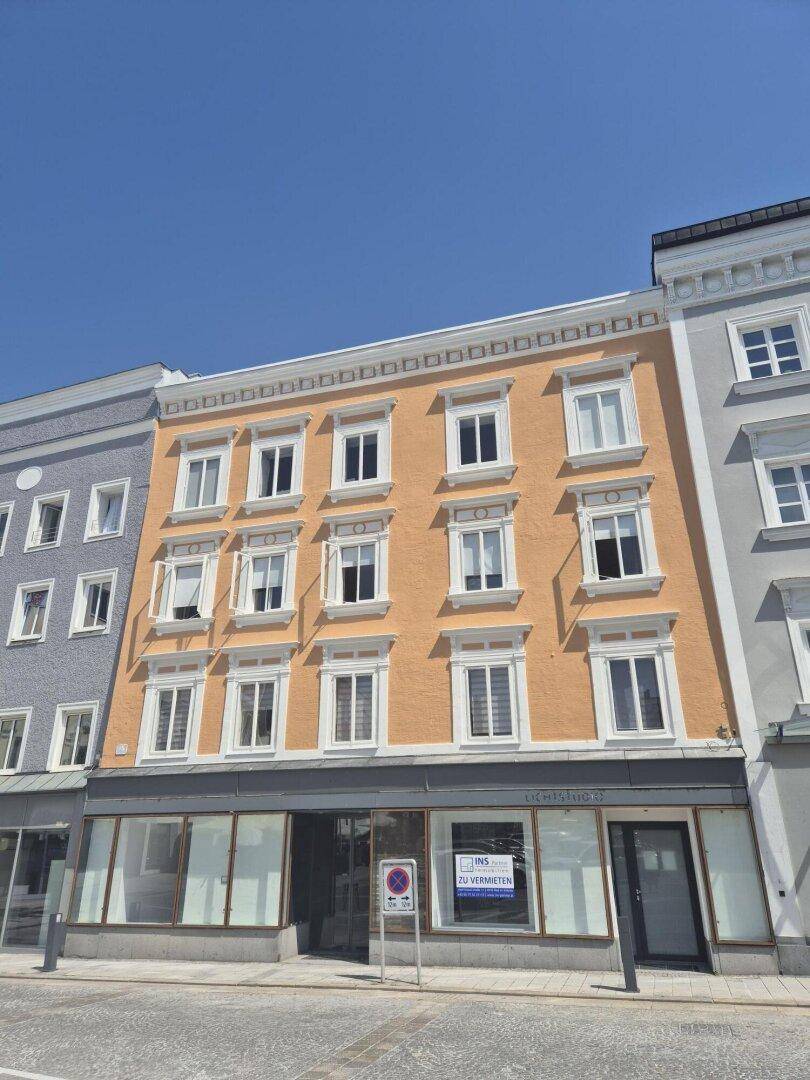 Historisches Gebäude mit einer gut erhaltenen orangefarbenen Fassade und weißen Fensterrahmen in einer städtischen Umgebung.