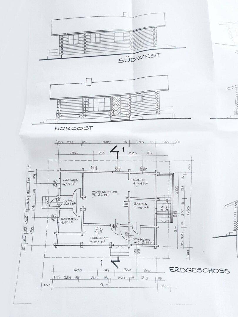 Grundriss des Erdgeschosses mit Küche, Wohnzimmer, Sauna und Terrasse.
