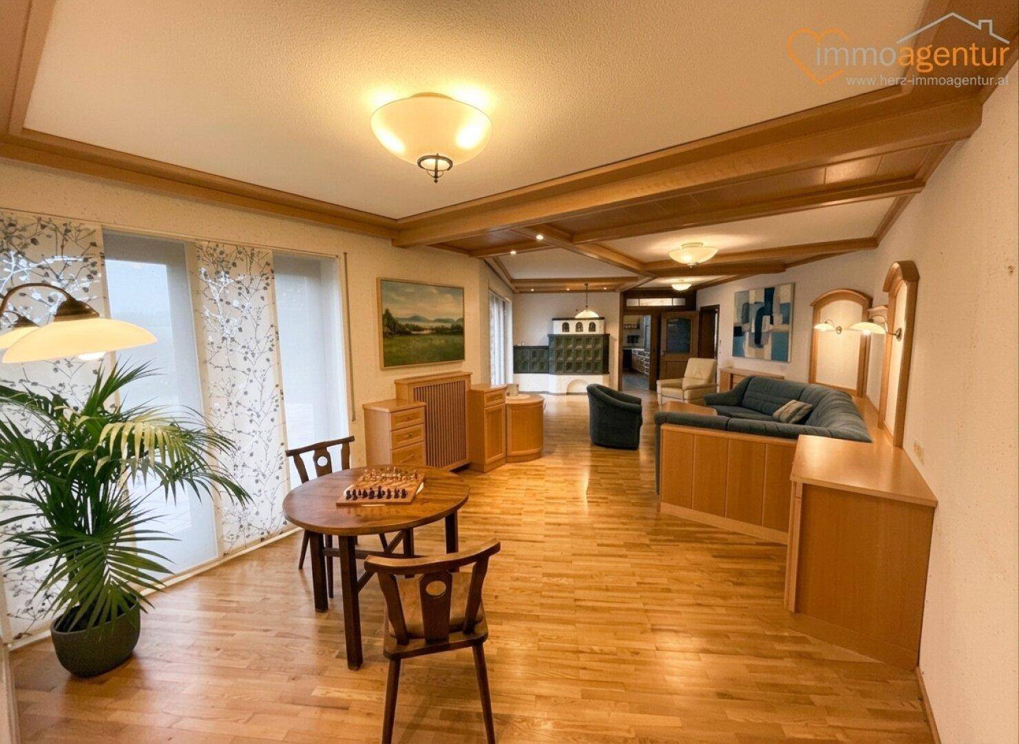 Helles Wohnzimmer mit Holzboden, traditionellen Möbeln und Blick in den Garten.