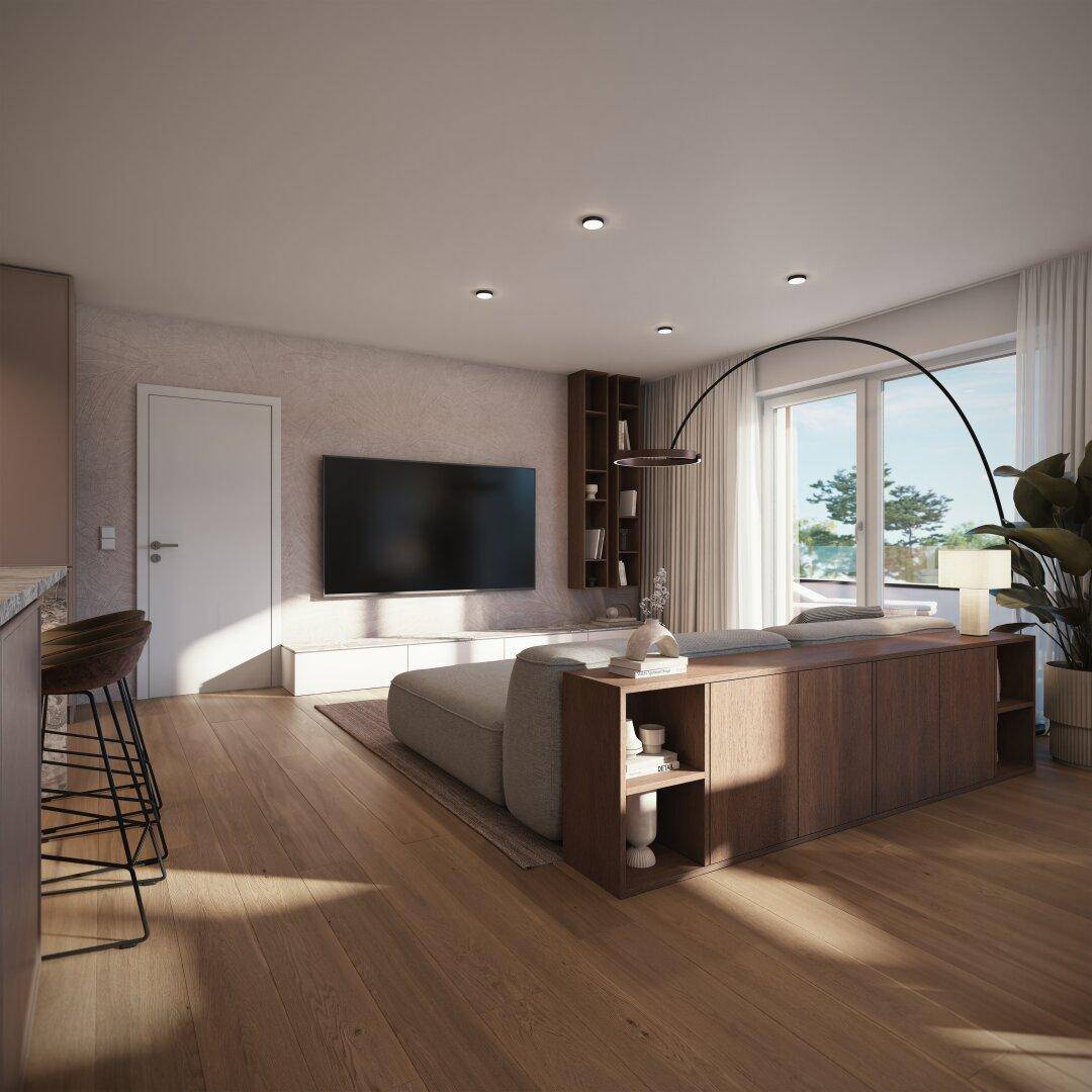 Gemütliches Wohnzimmer mit großem Sofa, Wandfernseher und Zugang zu einem Außenbereich.