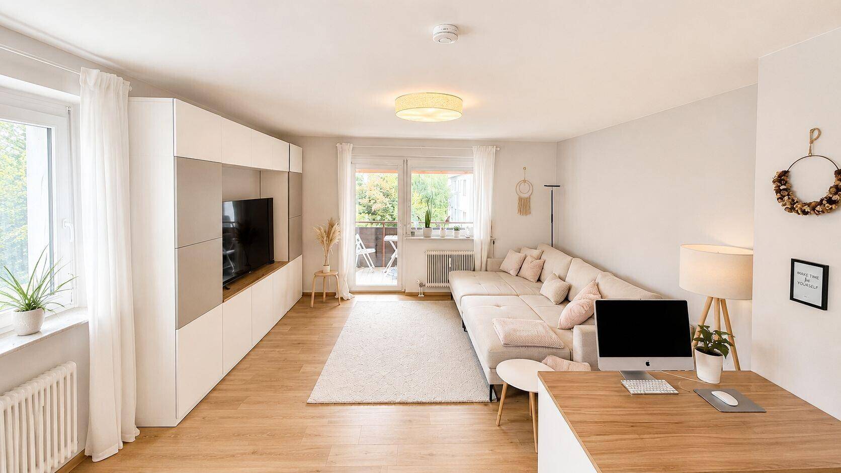 Gemütliches Wohnzimmer mit Sofa, TV-Möbel und Zugang zum Balkon.