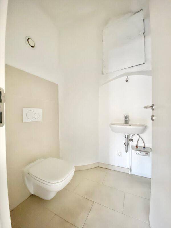 Modernes Gäste-WC mit wandhängender Toilette und kleinem Waschbecken.