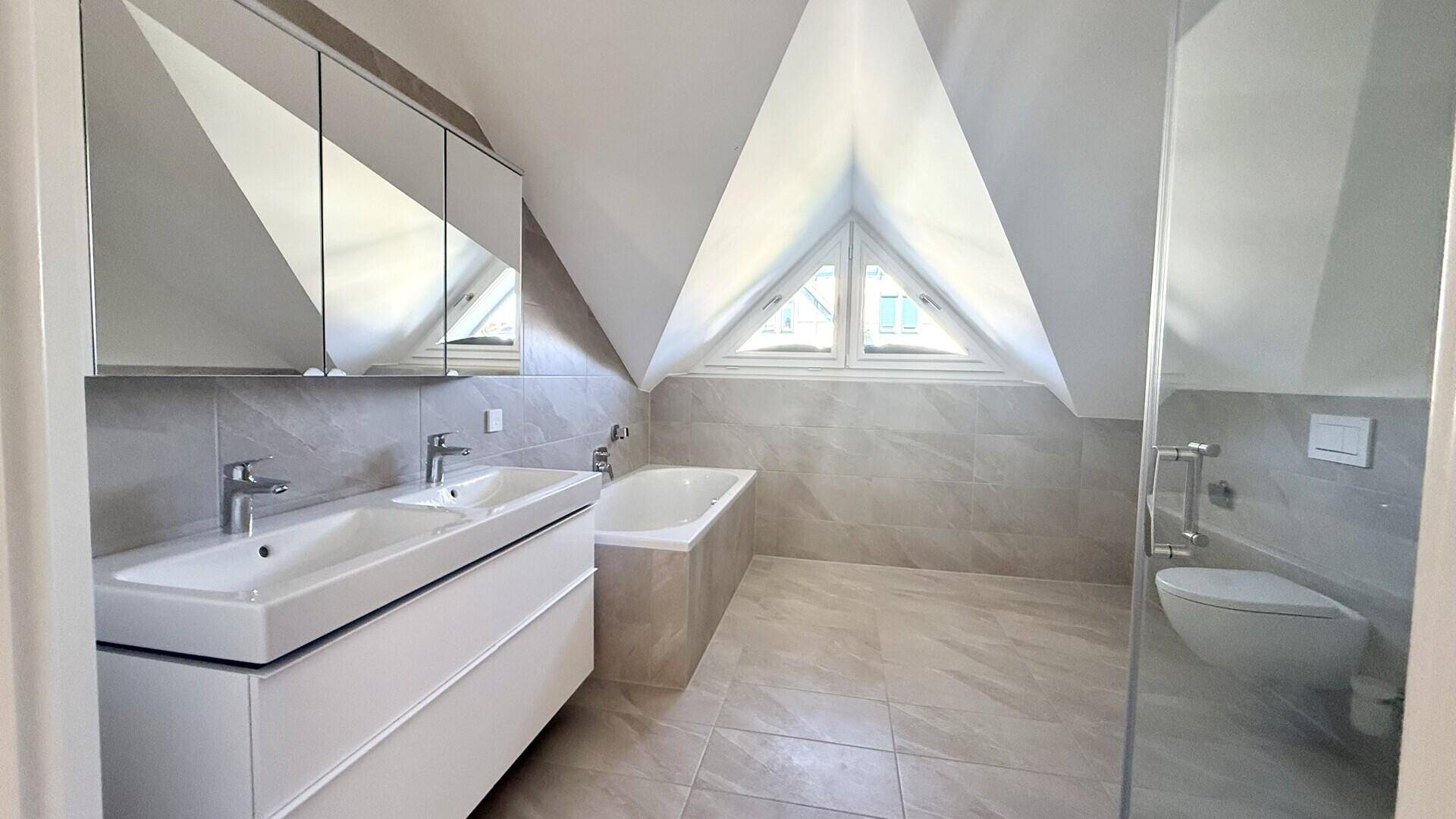 Modernes Dachgeschoss-Badezimmer mit Doppelwaschbecken, Badewanne und begehbarer Dusche.