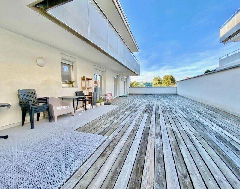 Geräumige Terrasse mit Holzbelag und ausreichend Fläche für verschiedene Gestaltungsmöglichkeiten.