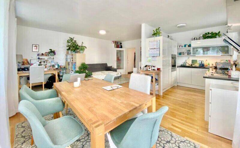 Offener Wohnbereich mit Essplatz, integrierter Küche und einem Arbeitsbereich, ideal für modernes Wohnen.