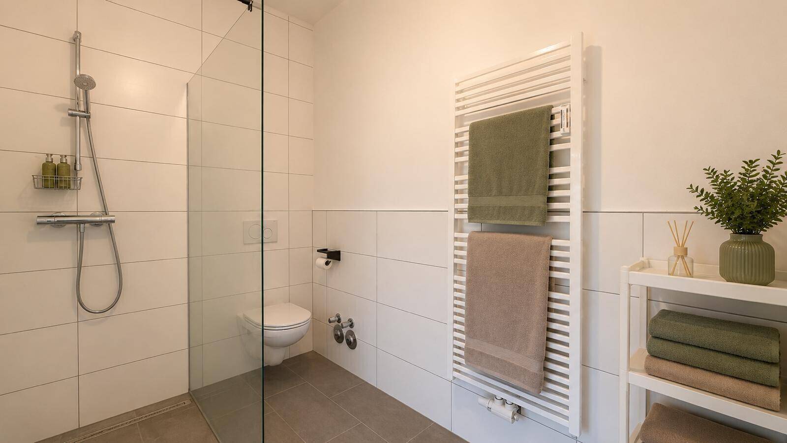 Helles Badezimmer mit großer ebenerdiger Dusche und modernen Fliesen.