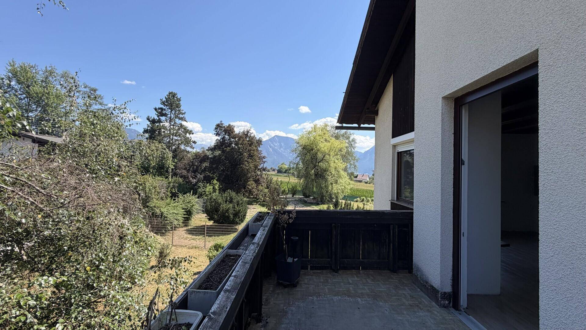 Geräumiger Balkon mit Bergblick und viel Grün in der Umgebung.