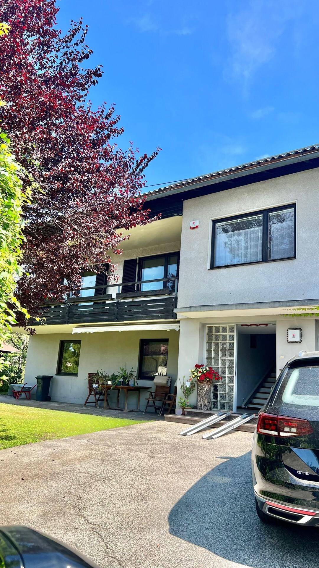 Vorderansicht des Hauses mit Balkonen, Fenstern und Zufahrt.