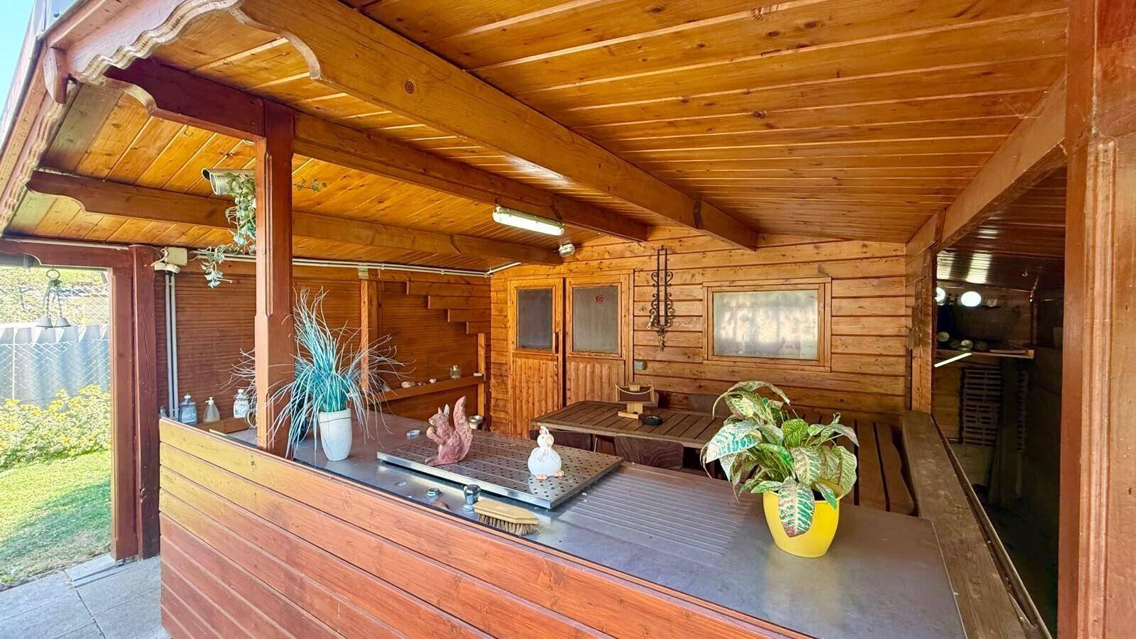 Überdachter Außenbereich aus Holz mit einer Theke und rustikalem Charme, ideal für gesellige Stunden.