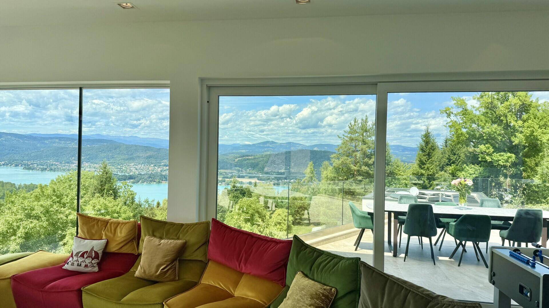Geräumiges Wohnzimmer mit modernen Sofas, großen Schiebetüren und direktem Zugang zur Terrasse.