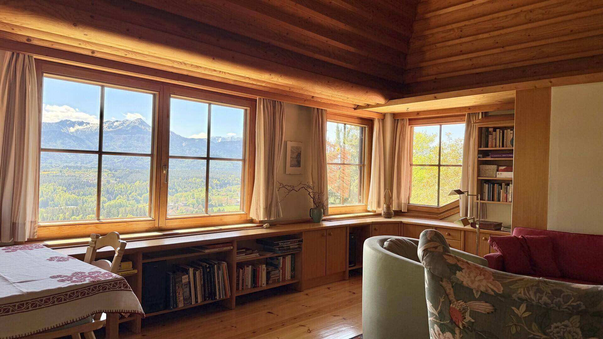 Lichtdurchfluteter Wohnbereich mit großen Fenstern, die einen atemberaubenden Bergblick bieten.