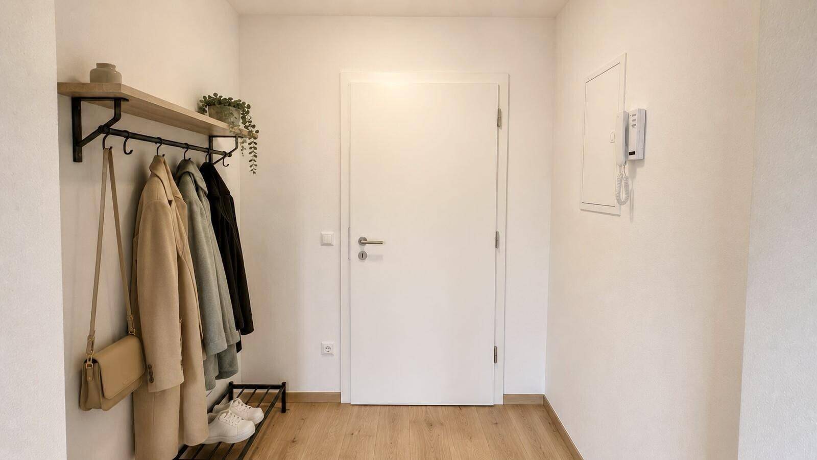Heller Eingangsbereich mit Garderobe und Gegensprechanlage.