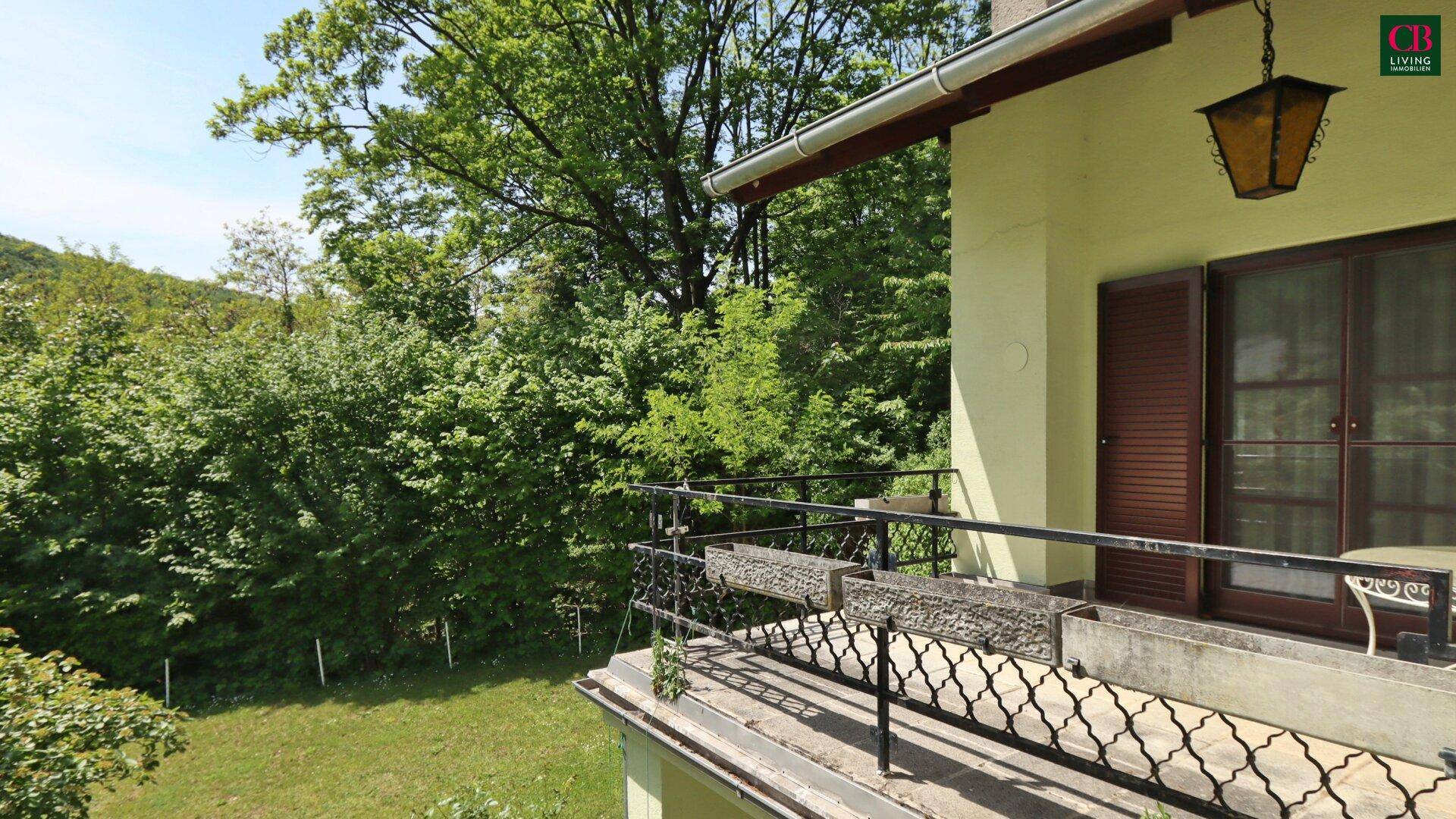 Kleiner Balkon mit schmiedeeisernem Geländer und weitem Blick auf die grüne Landschaft.