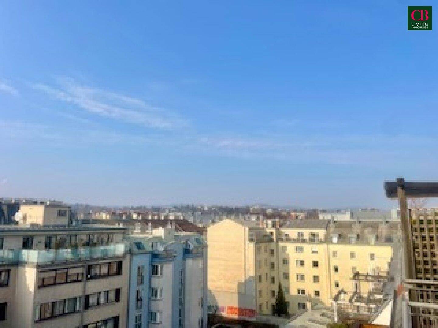 Weitläufiger Blick über die Stadt mit verschiedenen Gebäuden unter blauem Himmel.