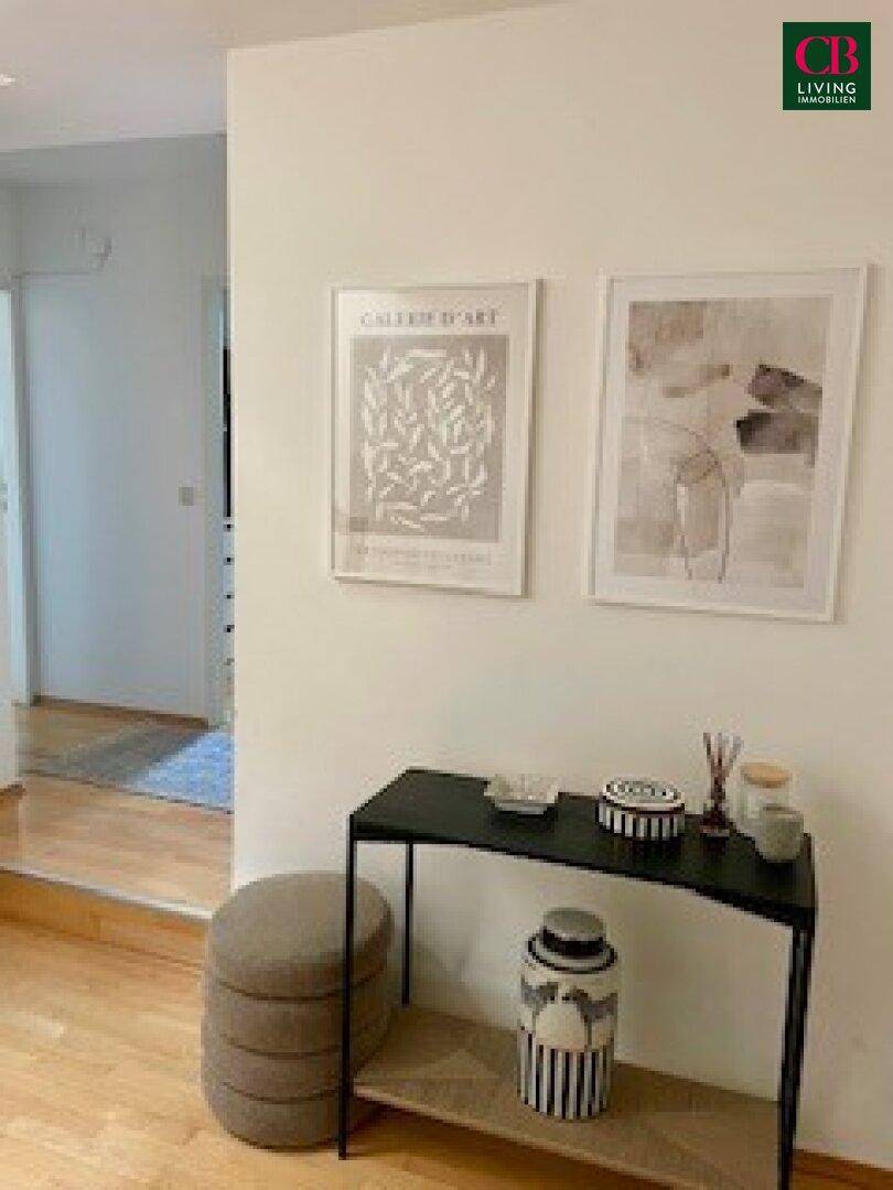 Eingangsbereich mit Holzboden, moderner Dekoration und Kunstwerken an der Wand.