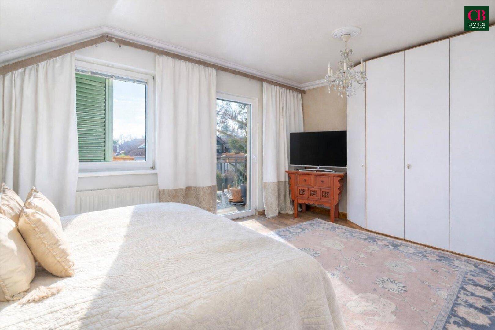 Schlafzimmer mit Balkonzugang, Einbauschränken und Teppichboden.