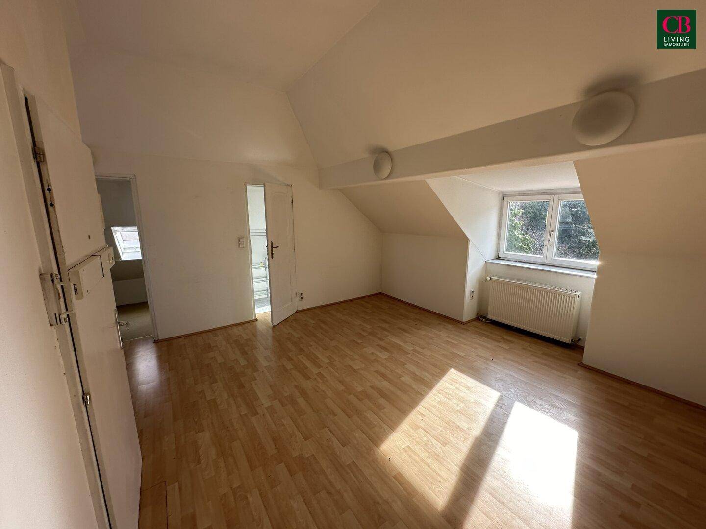 Geräumiges Dachgeschoss-Schlafzimmer mit Laminatboden und schrägen Wänden.